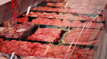 A full selection of premium meat cuts displayed at a butcher's shop.